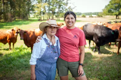 Maria Contreras, left, and her daughter, Lorena Jenkins, stand for a portrait after feeding cattle at their family farm in Blevins, Ark. on Sept. 7, 2023. Photo by Rory Doyle.